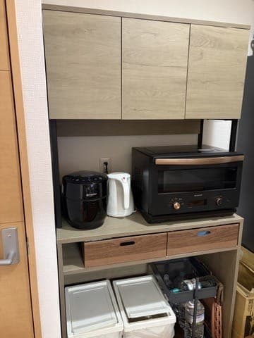 RASIK kitchen board Liora holding a toaster oven and trash bins