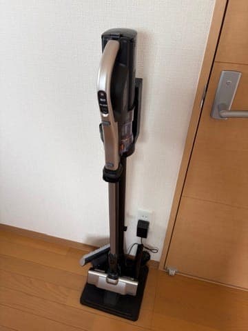 Hitachi Pawakaru Stick PV-BL50L cordless vacuum on its charging stand in the corner of our living room